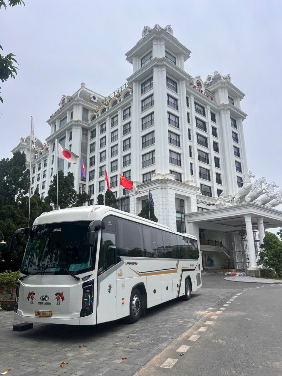 Xe du lịch 45 chỗ màu trắng trước khách sạn ở Hà Nội, NHD Travel